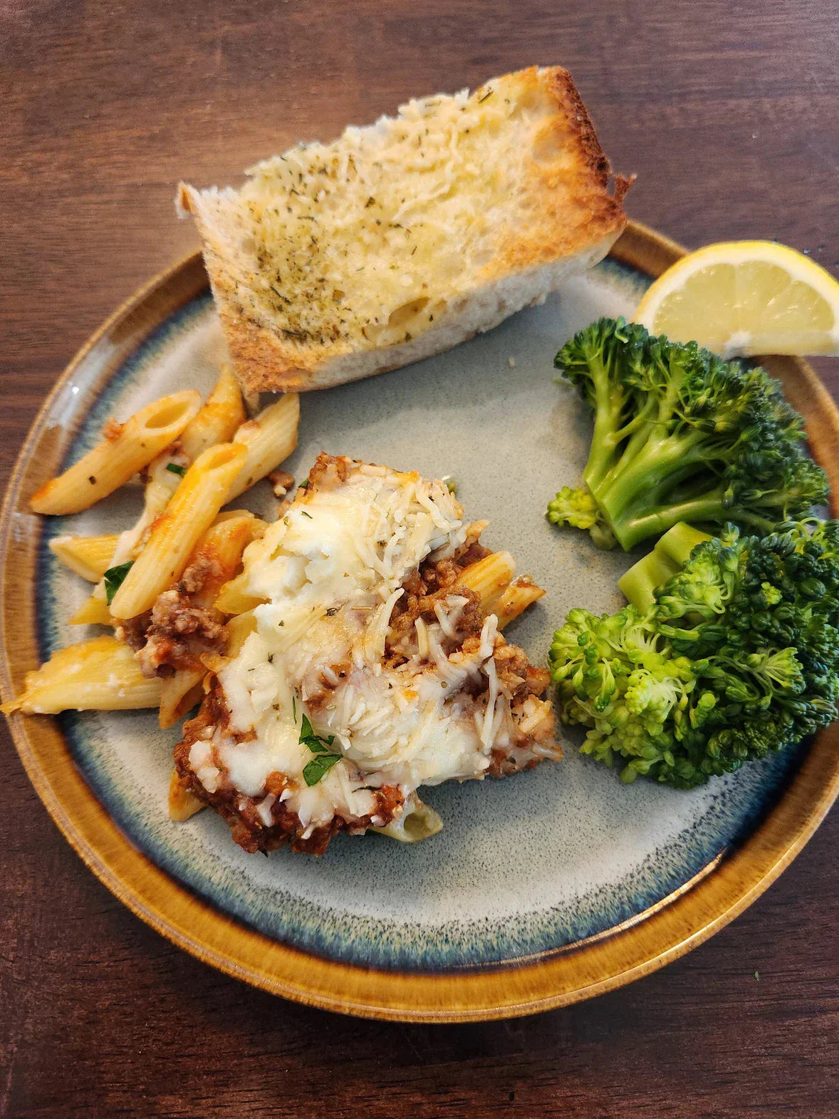 Baked ziti layered with Diamond R ground beef, ricotta, and melted mozzarella in a casserole dish.