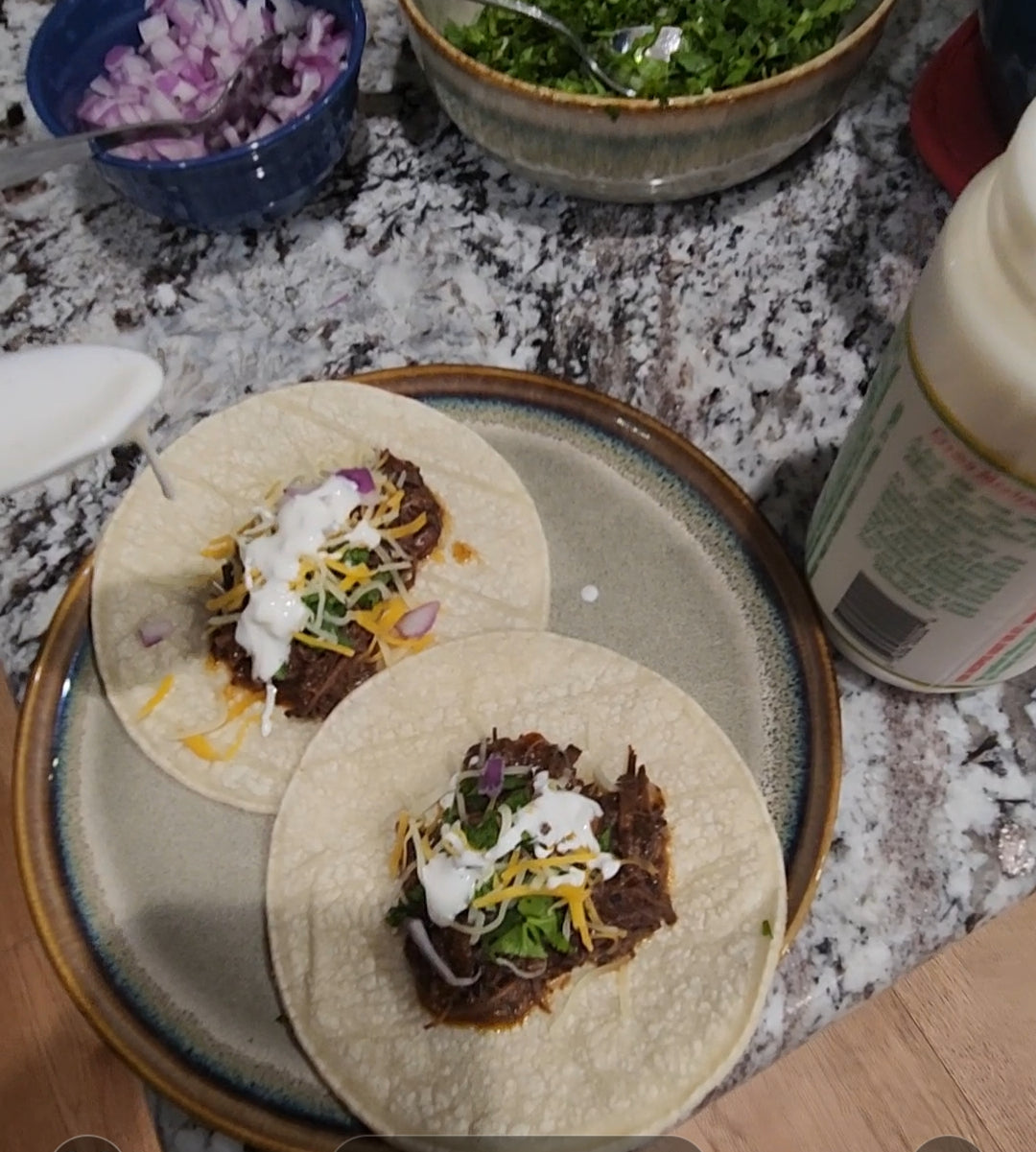 Shredded beef barbacoa tacos made from chuck roast on warm corn tortillas with cilantro, onion, and lime